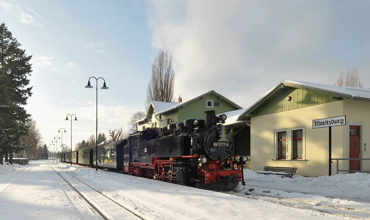 A steam locomotive waiting beside a railway platform
