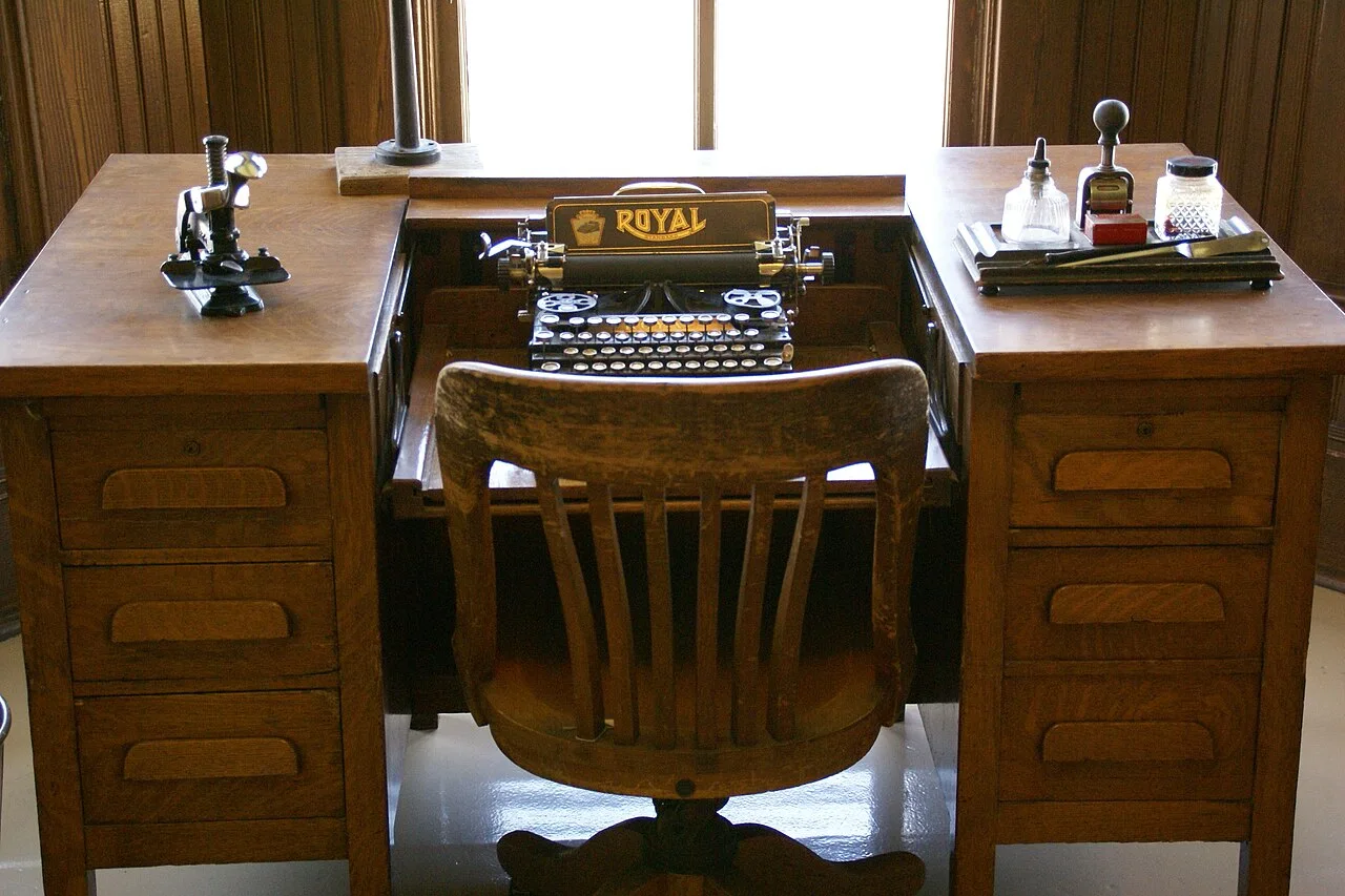 An old typewriter on a wooden desk