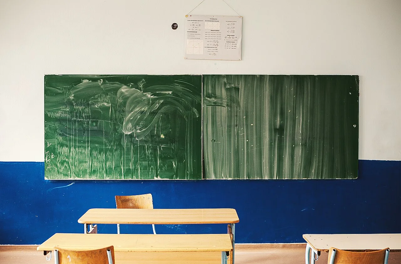 An old classroom with wooden desks and a chalkboard