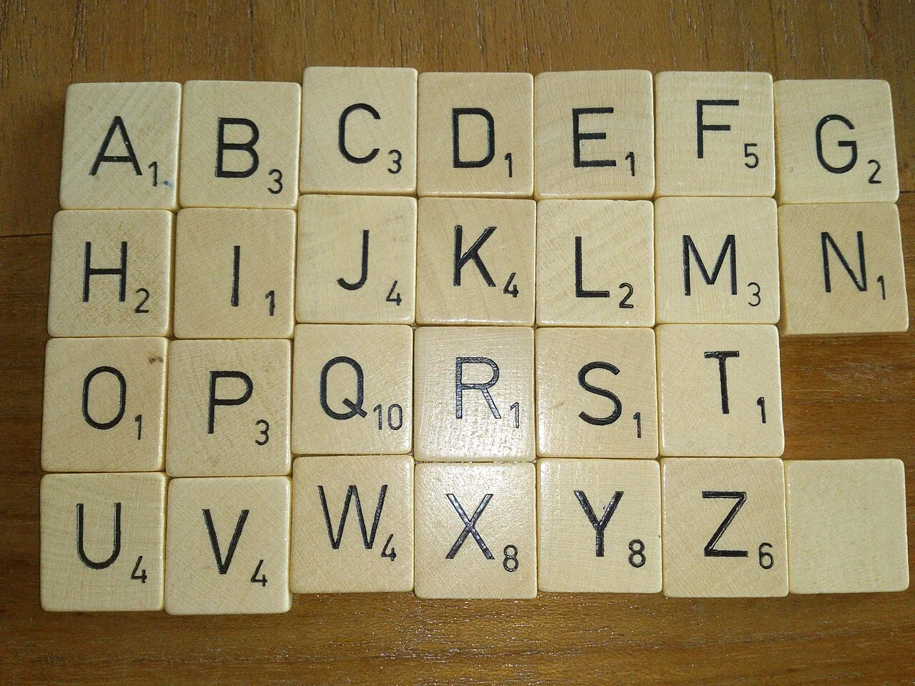 Wooden alphabet tiles arranged in rows