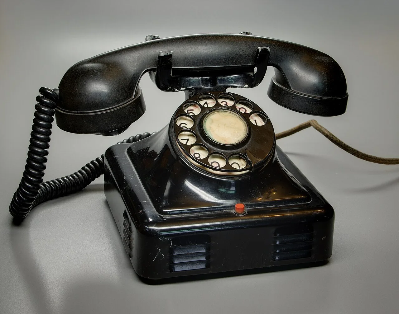 A black rotary dial telephone